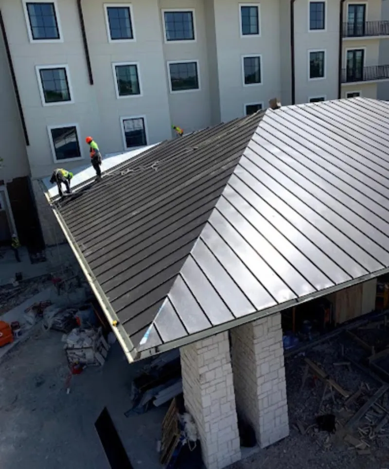 Crew installing standing seam metal roof panels on a commercial project in Wolf Trap